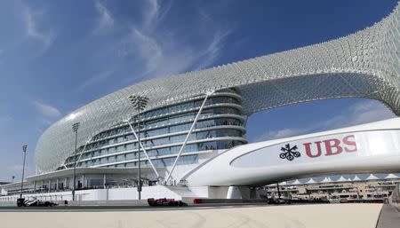 Formula One cars drive past the Yas Marina hotel during the first practice session of the Abu Dhabi F1 Grand Prix at the Yas Marina circuit in Abu Dhabi November 21, 2014. REUTERS/Caren Firouz