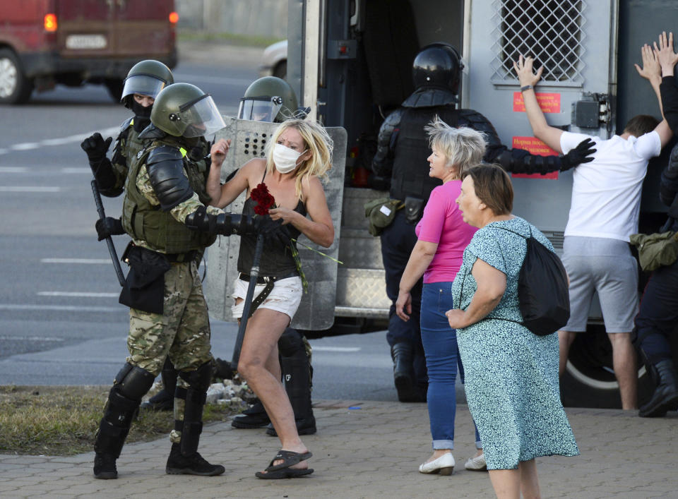 FILE - In this Aug. 11, 2020, file photo, a woman fights with a police officer as others detain a protester in the capital of Minsk, Belarus. When Belarusians protested what they called a fraudulent election on Aug. 9, police used tear gas, flash grenades and beatings in a harsh crackdown. But now President Alexander Lukashenko is moving to squelch the demonstrations gradually with vague promises of reforms mixed with threats, court summonses and the selective jailing of leading activists. (AP Photo/File)