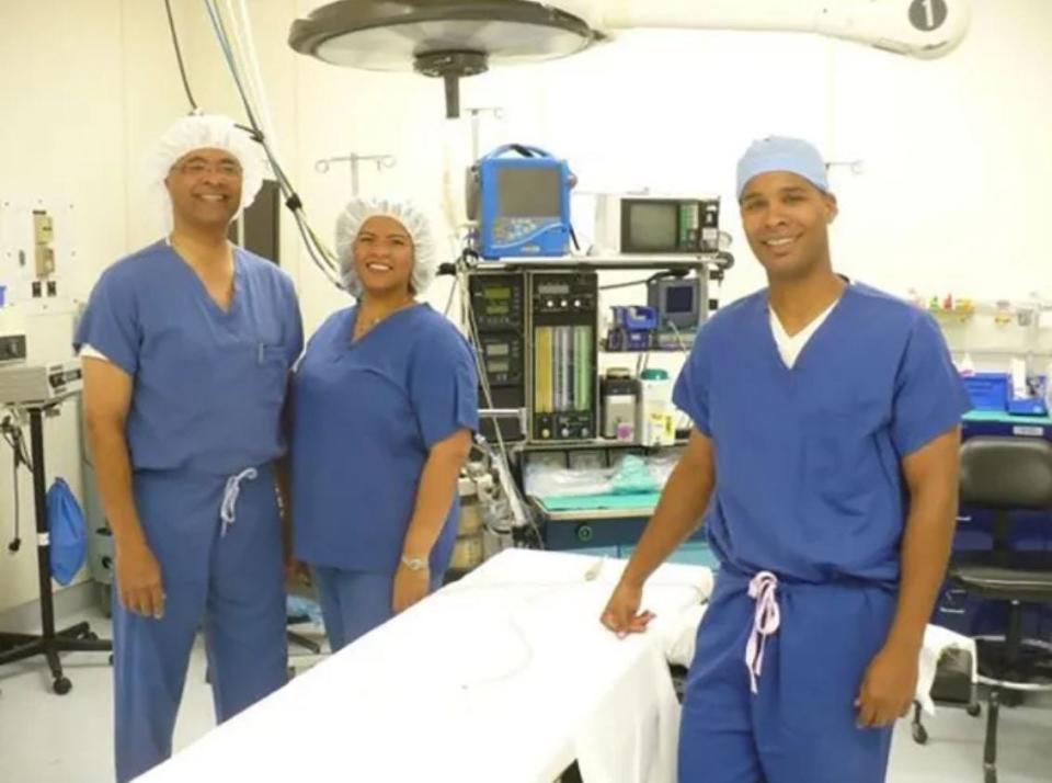 The Tate family stand in one of Patients' Hospital's operating rooms during the hospital's 20th anniversary in 2012. Left to right: Patients' Hospital founder and neurosurgeon James Tate; his daughter, psychologist Lea Tate; and his son, facial plastic surgeon Randy Tate.