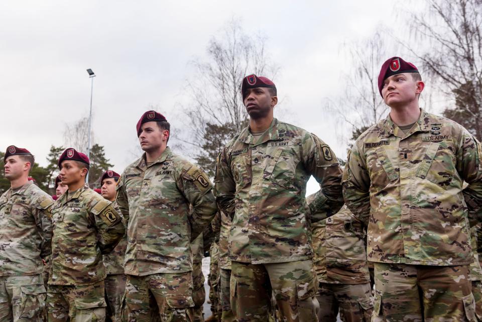 A group of US Army men stand at attention.