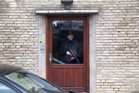 Policeman stands guard in an apartment block during a search for suspects believed to have travelled to Syria to join the Islamic State, in Tingbjerg, Copenhagen, April 7, 2016. REUTERS/Uffe Weng/Scanpix Denmark