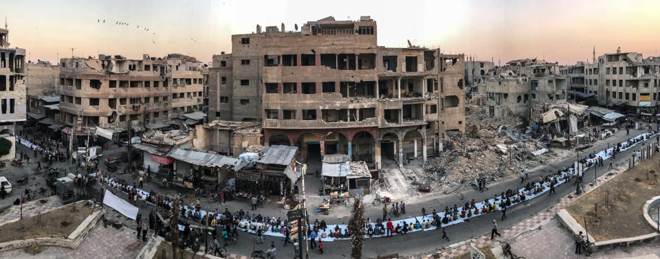 First Place<br />"Iftar Amongst the Ruins"<br />During a lull in the bombings, Syrians gather, seated on a long 1200-meter row of tables set up among the ruins of Douma, for a public Iftar, the evening meal at the end of the daily Ramadan fast. <br />Shot on iPhone 7