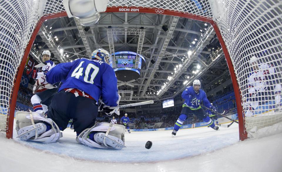 Team USA's Phil Kessel (R) scores his third goal of the game on Slovenia's goalie Luka Gracnar as USA's James van Riemsdyk (L) and Slovenia's Mitja Robar look on during second period of their men's preliminary round ice hockey game at the 2014 Sochi Winter Olympics, February 16, 2014. REUTERS/Matt Slocum/Pool (RUSSIA - Tags: OLYMPICS SPORT ICE HOCKEY)