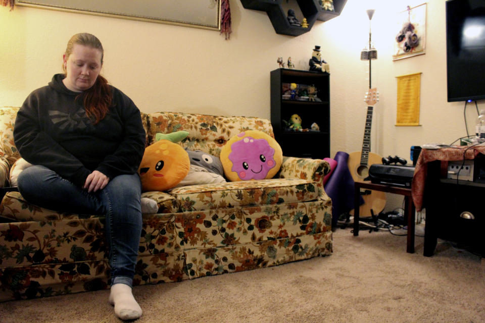 Taylor Wood sits on the couch in her Corvallis, Ore., apartment on Dec. 11, 2020. The Oregon native, who is 10 weeks pregnant, has not been able to get much sleep as she stresses about finances during the pandemic. (AP Photo/Sara Cline)