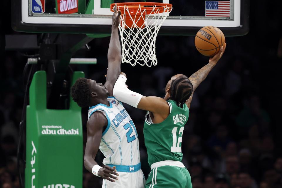 Boston Celtics' Oshae Brissett (12) shoots against Charlotte Hornets' JT Thor (21) during the first half of an NBA basketball game, Friday, April 12, 2024, in Boston. (AP Photo/Michael Dwyer)