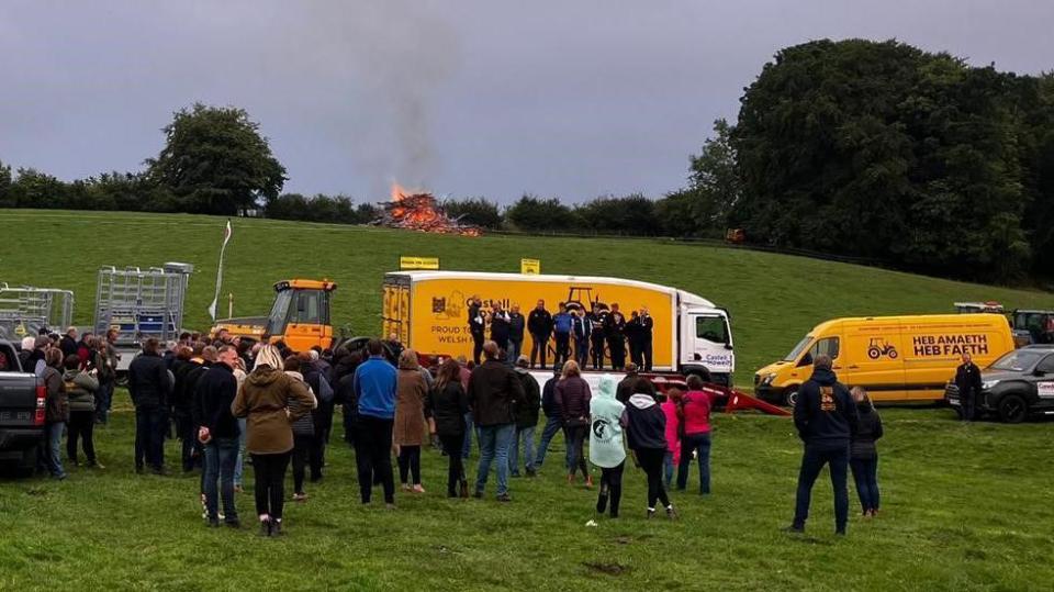 Supporters of the Enough is Enough farmers' pressure group with vehicles and a bonfire on a farm
