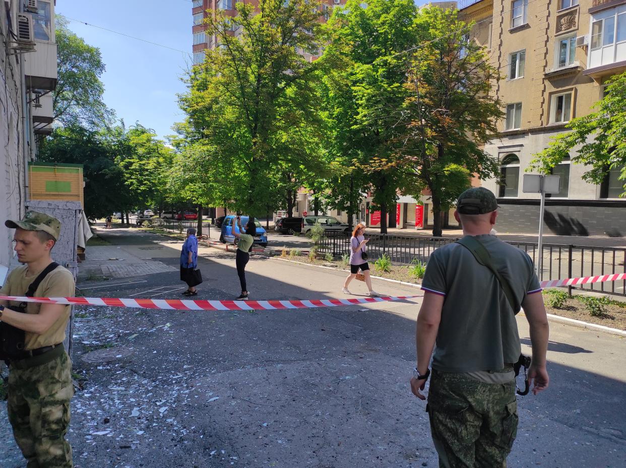 DONETSK, UKRAINE - JUNE 08 : People looks on a residential building damaged by shelling in Leninsky district of Donetsk, Ukraine on June 08, 2022, as Russian attacks continue. (Photo by Leon Klein/Anadolu Agency via Getty Images)