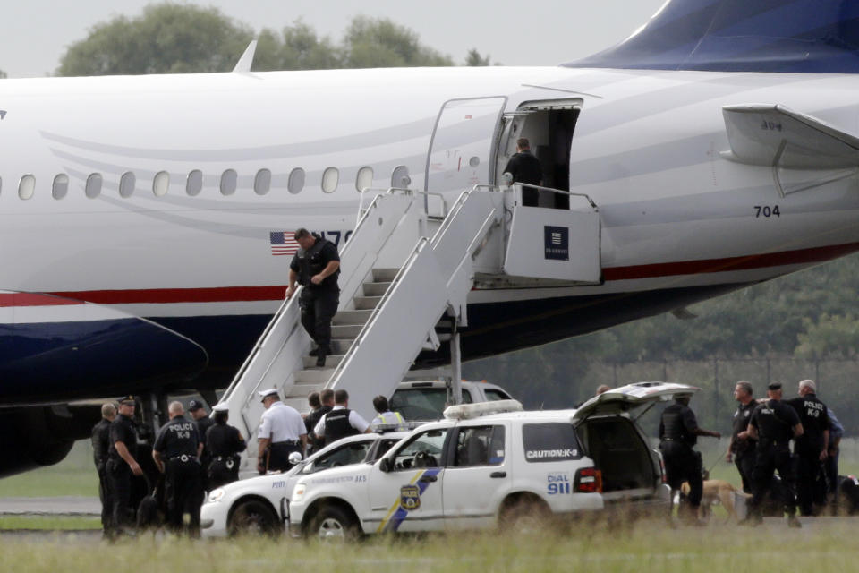 Law enforcement officials work around a US Airways flight at Philadelphia International Airport, after the plane returned to the airport, Thursday, Sept. 6, 2012, in Philadelphia. A security scare that prompted authorities to recall an airborne U.S. flight was the result of an apparent hoax, police said Thursday. (AP Photo/Matt Rourke)