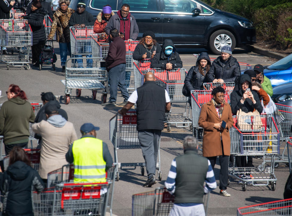 Shoppers queue outside a branch of Costco, in Croydon, south London, on the weekend after Prime Minister Boris Johnson ordered pubs and restaurants across the country to close as the Government announced unprecedented measures to cover the wages of workers who would otherwise lose their jobs due to the coronavirus outbreak. (Photo by Dominic Lipinski/PA Images via Getty Images)