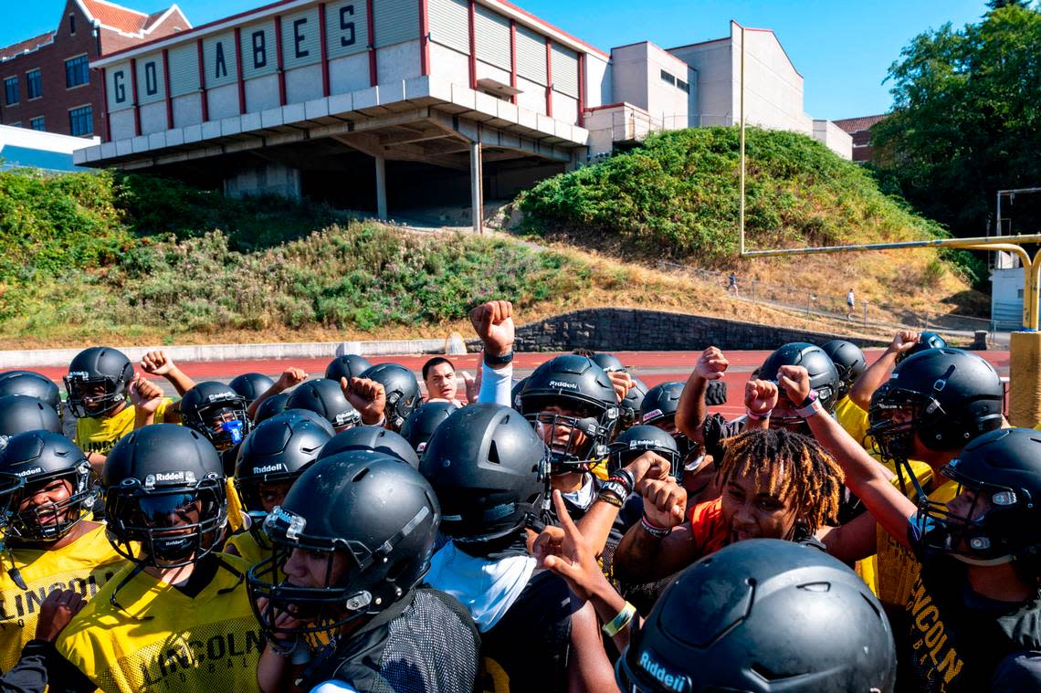 Lincoln players break a team huddle at the outset of the opening practice of the 2022 season on Wednesday, Aug. 17, 2022, at Lincoln High School in Tacoma, Wash.