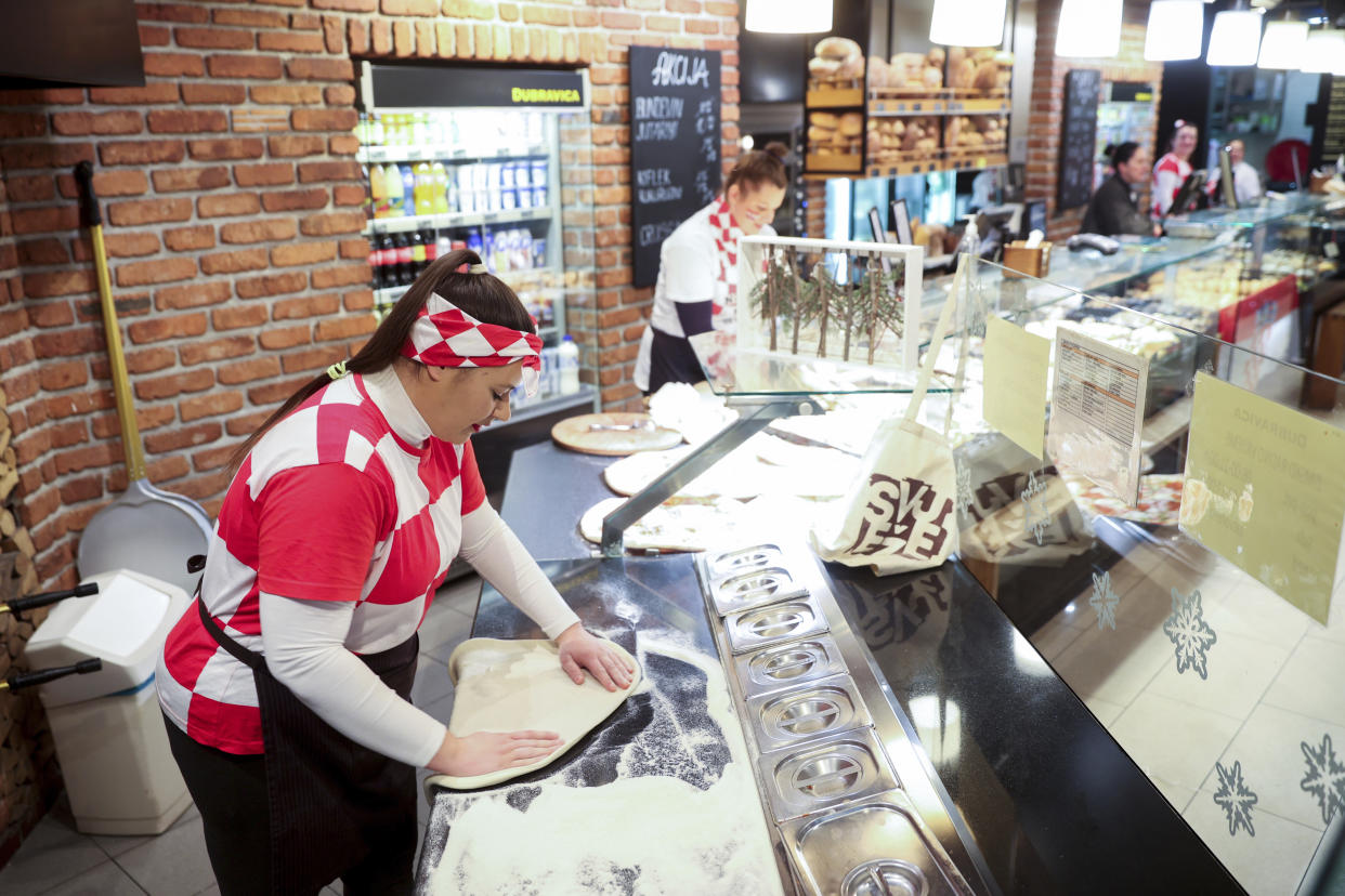 Bakery workers wear Croatia football jerseys prior to the Qatar World Cup semi-final match between Croatia and Argentina, in Zagreb, Croatia, Tuesday, Dec. 13, 2022. (AP Photo/Armin Durgut)