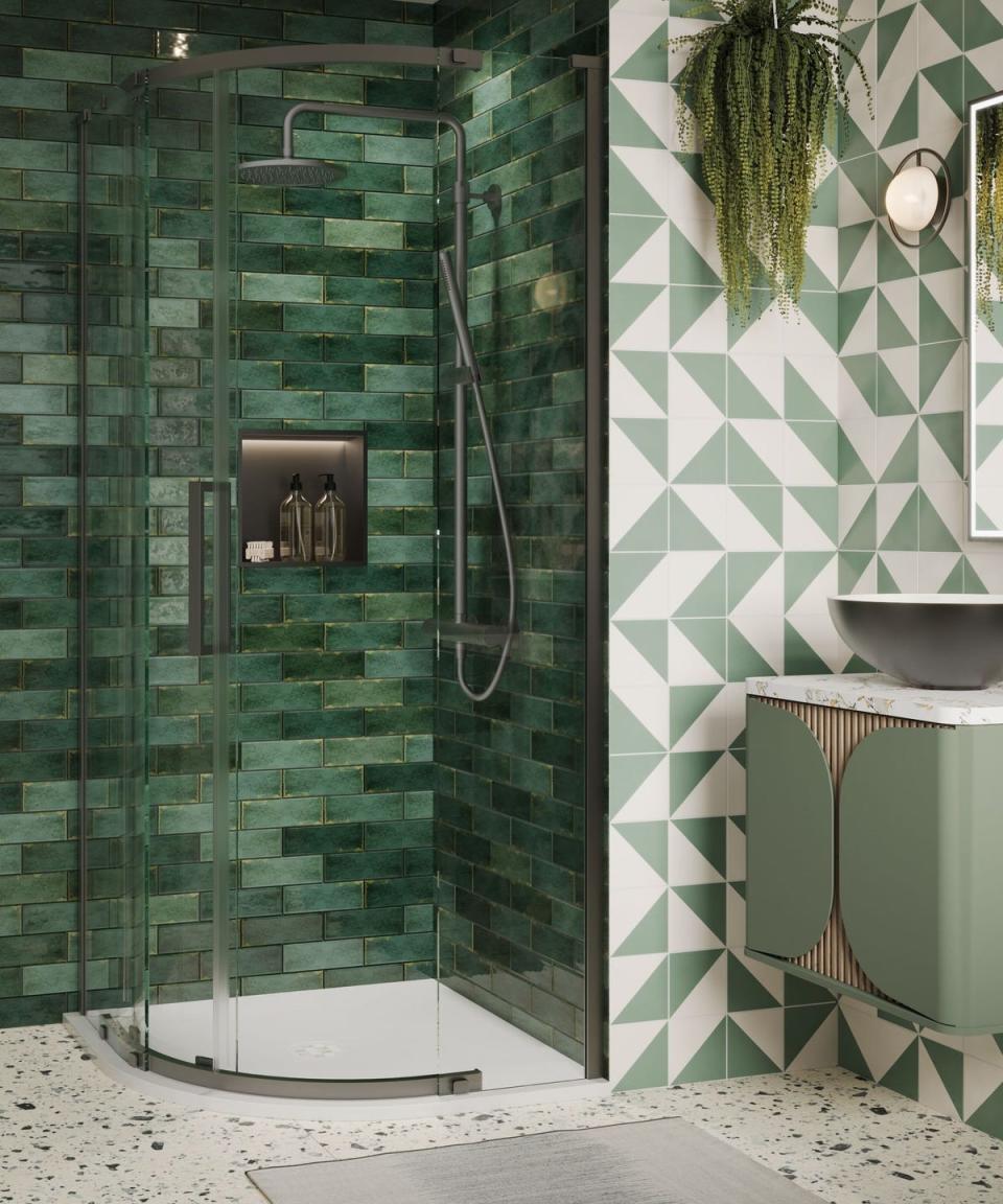 corner shower with green tiles and a black shower niche