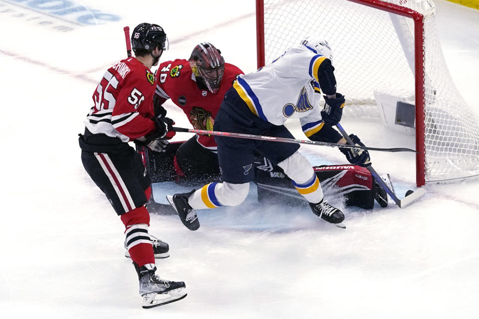 St. Louis Blues left wing Jake Neighbours, right, scores against Chicago Blackhawks goaltender Arvid Soderblom and defenseman Kevin Korchinski during the first period of an NHL hockey game in Chicago, Sunday, Nov. 26, 2023. (AP Photo/Nam Y. Huh)