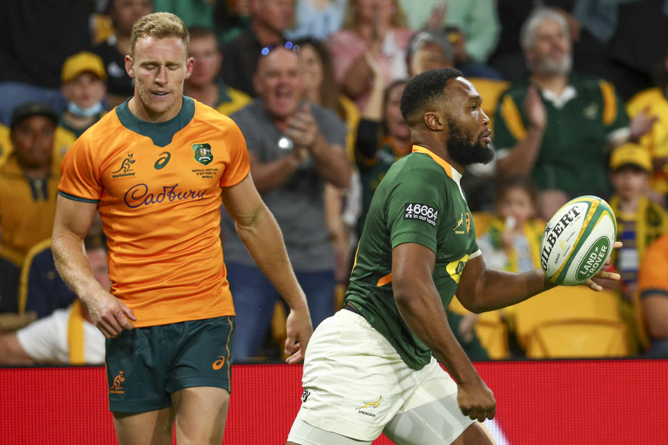 South Africa's Lukhanyo Am, right, reacts after scoring try as Australia's Reece Hodge watches during the Rugby Championship test match between the Springboks and the Wallabies in Brisbane, Australia, Saturday, Sept. 18, 2021. (AP Photo/Tertius Pickard)