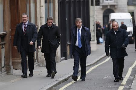 Russian billionaire and owner of Chelsea football club Roman Abramovich (2nd R) walks past the High Court in London November 16, 2011. REUTERS/Suzanne Plunkett/Files