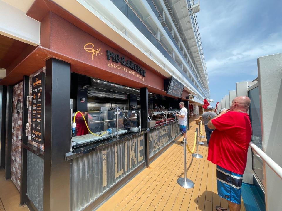 A passenger studies the menu before stepping into Guy's Pig & Anchor Bar-B-Que's buffet line.