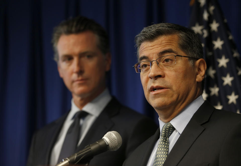 California Attorney General Xavier Becerra, right, flanked by Gov. Gavin Newsom, discusses the Trump administration's pledge to revoke California's authority to set vehicle emissions standards that are different than the federal standards, during a news conference in Sacramento, Calif., Wednesday, Sept. 18, 2019. (AP Photo/Rich Pedroncelli)