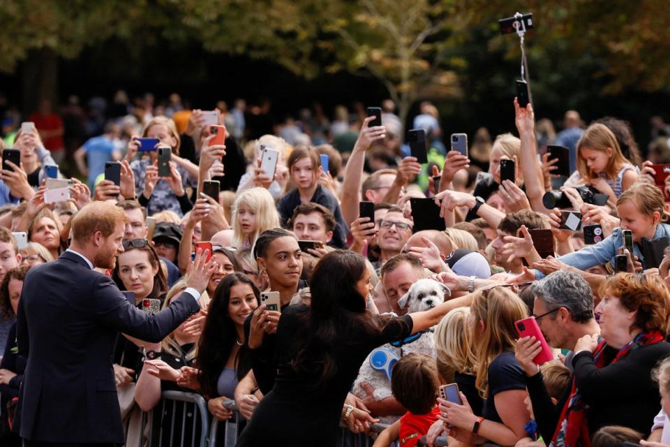 Prince Harry and Meghan, the Duchess of Sussex, greet people as they walk outside Windsor Castle, following the passing of Britain’s Queen Elizabeth (REUTERS)