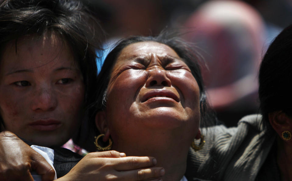 Relatives of mountaineers, killed in an avalanche on Mount Everest, cry during the funeral ceremony in Katmandu, Nepal, Monday, April 21, 2014. Buddhist monks cremated the remains of Sherpa guides who were buried in the deadliest avalanche ever recorded on Mount Everest, a disaster that has prompted calls for a climbing boycott by Nepal's ethnic Sherpa community. The avalanche killed at least 13 Sherpas. Three other Sherpas remain missing and are presumed dead. (AP Photo/Niranjan Shrestha)