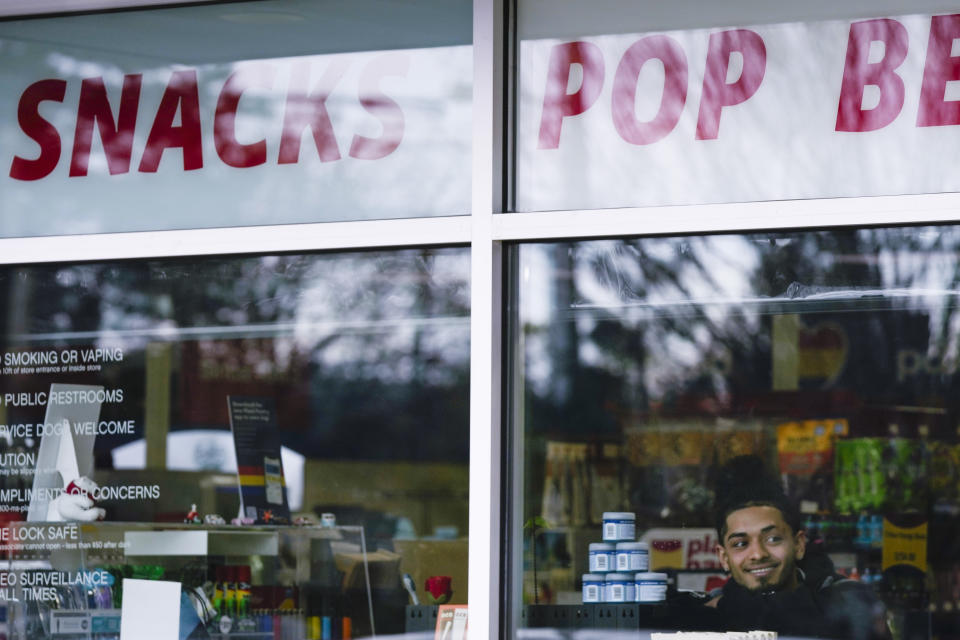 Plaid Pantry cashier Darling Hinojosa looks out the window as members of the media begin to gather for a news conference outside the convenience store on Tuesday, April 9, 2024, in Portland, Ore. A ticket matching all six Powerball numbers in Saturday's $1.3 billion jackpot was sold at the store. (AP Photo/Jenny Kane)