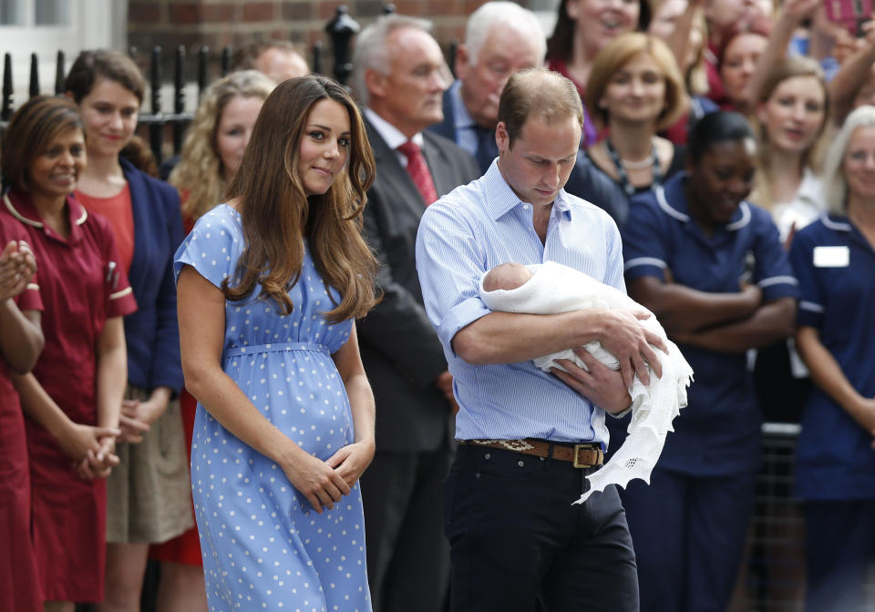 This July 23, 2013 file photo shows Britain's Prince William, right, and Kate, Duchess of Cambridge with the Prince of Cambridge as they pose for photographers outside St. Mary's Hospital in London. Princess Diana wore a caftan-like outfit that hid the post-childbirth tummy bump when William was born. In contrast, the former Kate Middleton, in her first public appearance on July 23, 2013, after giving birth, wore a dress that did not camouflage her belly, and many women are applauding her choice. (AP Photo/Sang Tan, File)