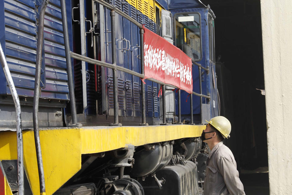 An employee of the Sangwon Cement Complex watches loads of cement leave on a train for building projects in Sangwon county, North Hwanghae Province, North Korea, Nov. 5, 2020. North Korea is staging an “80-day battle,” a propaganda-heavy productivity campaign meant to bolster its internal unity and report greater production in various industry sectors ahead of a ruling party congress in January. (AP Photo/Cha Song Ho)