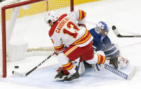 Calgary Flames' Johnny Gaudreau (13) scores the game winning goal on Toronto Maple Leafs goaltender David Rittich (33) in overtime of an NHL hockey game Tuesday, April 13, 2021 in Toronto. (Frank Gunn/Canadian Press via AP)