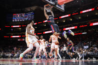 Detroit Pistons forward Marvin Bagley III (35) hangs from the rim after slam dunking the ball over Atlanta Hawks forward Onyeka Okongwu, left, guard Aaron Holiday, center, and guard Bogdan Bogdanovic, right, during the second half of an NBA basketball game Tuesday, March 21, 2023, in Atlanta. (AP Photo/Alex Slitz)