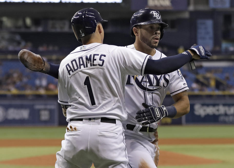 Tampa Bay Rays' Tommy Pham, right, hugs on-deck batter Willy Adames after scoring on an RBI single by Joey Wendle off Oakland Athletics pitcher Edwin Jackson during the fourth inning of a baseball game Friday, Sept. 14, 2018, in St. Petersburg, Fla. (AP Photo/Chris O'Meara)