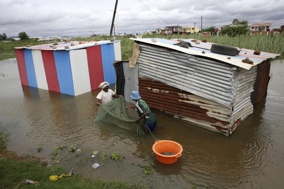 People use a net to catch fish around their flooded dwelling in Antananarivo, Madagascar, Monday, Jan. 24, 2022. Tropical storm Ana has caused widespread flooding in Madagascar, causing the deaths of 34 people and displacing more than 55,000, officials said Monday. With heavy rains continuing, rivers in Antananarivo are rising and officials are urging residents to leave low-lying areas of the capital city and surrounding areas. (AP Photo/Alexander Joe)