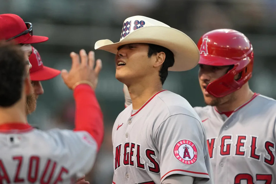 Shohei Ohtani wears a cowboy hat after hitting a home run.