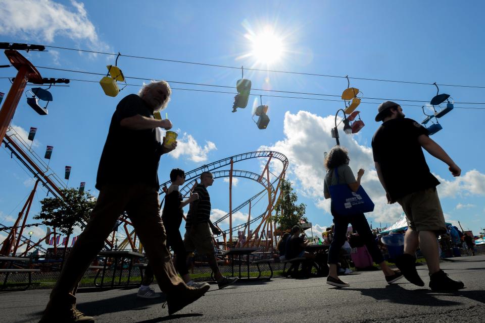 Fair goers walk around near rides and food vendors during opening day at the Great New York State Fair on Wednesday, August 21, 2019 in Geddes. [ALEX COOPER / OBSERVER-DISPATCH]