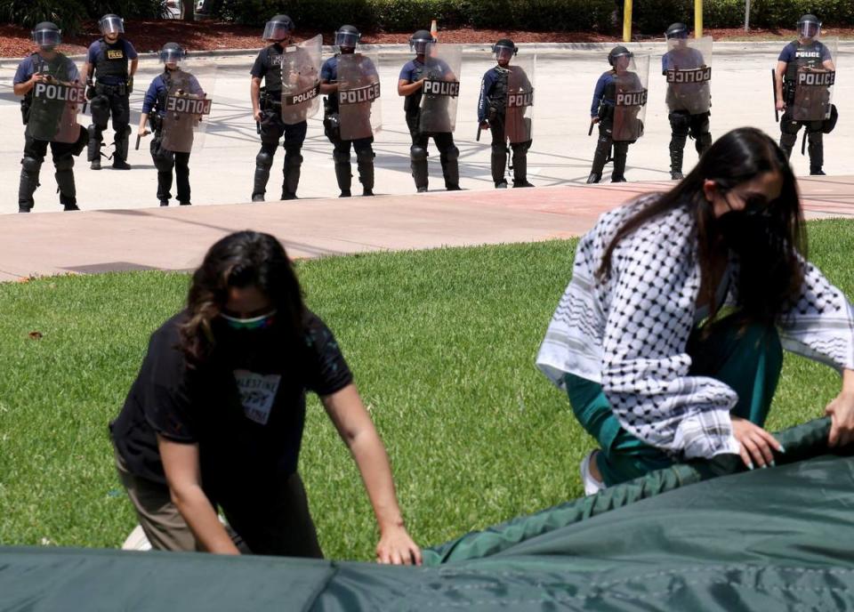 Miami Police officers in riot gear stand near as a group protesting for ceasefire in Gaza in Bayside Monday, April 15, 2024. Police arrested seven protesters accused of blocking the intersection of 3rd Street and northbound Biscayne Boulevard. Carl Juste/cjuste@miamiherald.com