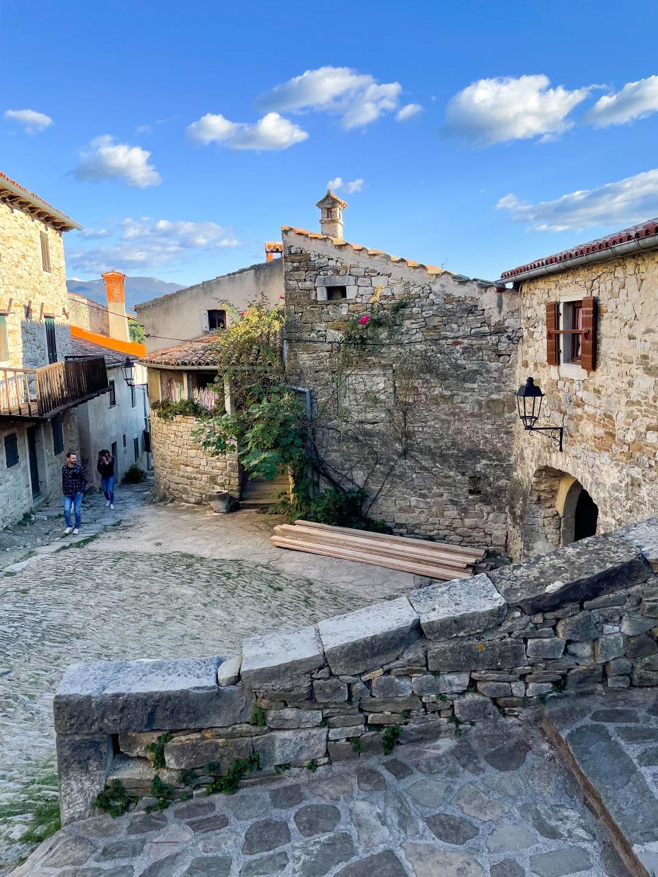 A cobblestone square with old-looking stone buildings.