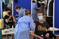 People receive the AstraZeneca vaccination against the coronavirus at the forum of the DITIB central mosque in Cologne, Germany, Saturday, May 8, 2021. (AP Photo/Martin Meissner)