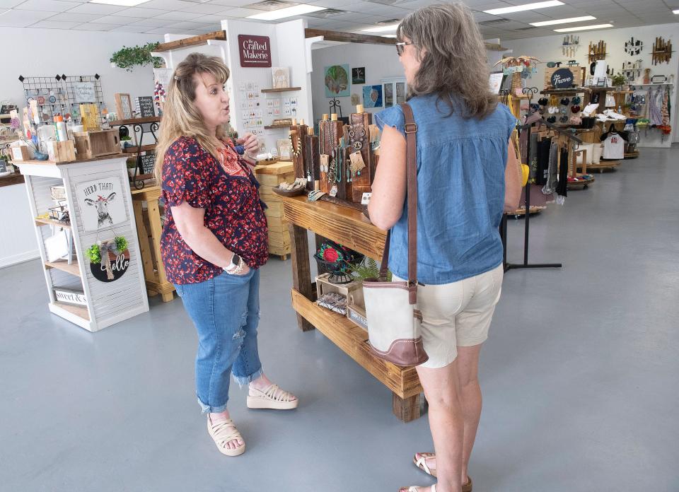 Flax Covington, the co-owner of the new Covington Mercantile & Coffee Company in Pea Ridge, talks with a customer on Tuesday, July 18, 2023. The coffee and specialty retailer opened its doors in early June 2023.