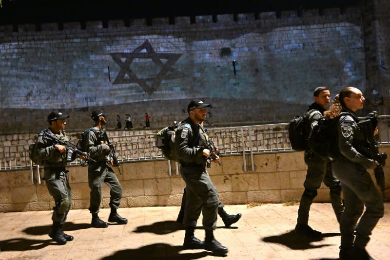 Israeli border police patrol in front of Israeli flag projected on the wall of the Old City of Jerusalem after Israel suffered a massive terrorist attack by Hamas on the Gaza border, on Wednesday. Photo by Debbie Hill/ UPI