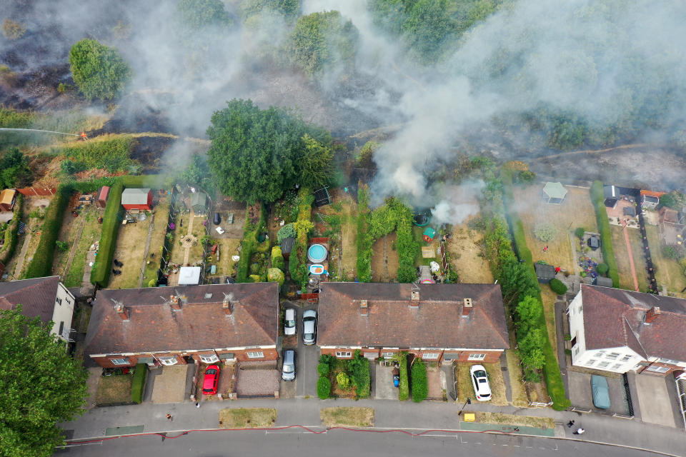 SHEFFIELD, ENGLAND - JULY 20: In this aerial view Firefighters contain a wildfire that encroached on nearby homes in the Shiregreen area of Sheffield on July 20, 2022 in Sheffield, England. Multiple fires have broke out across the UK yesterday and today as the UK experienced a record-breaking heatwave. Temperatures in many places reached 40c and over. (Photo by Christopher Furlong/Getty Images)