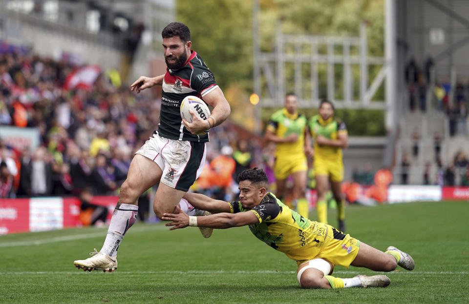 Lebanon's Abbas Miski gets away from Jamaica's Kieran Rush to score a try during the Rugby League World Cup group C match at the Leigh Sports Village, Leigh, England, Sunday, Oct. 30, 2022. (Tim Goode/PA via AP)