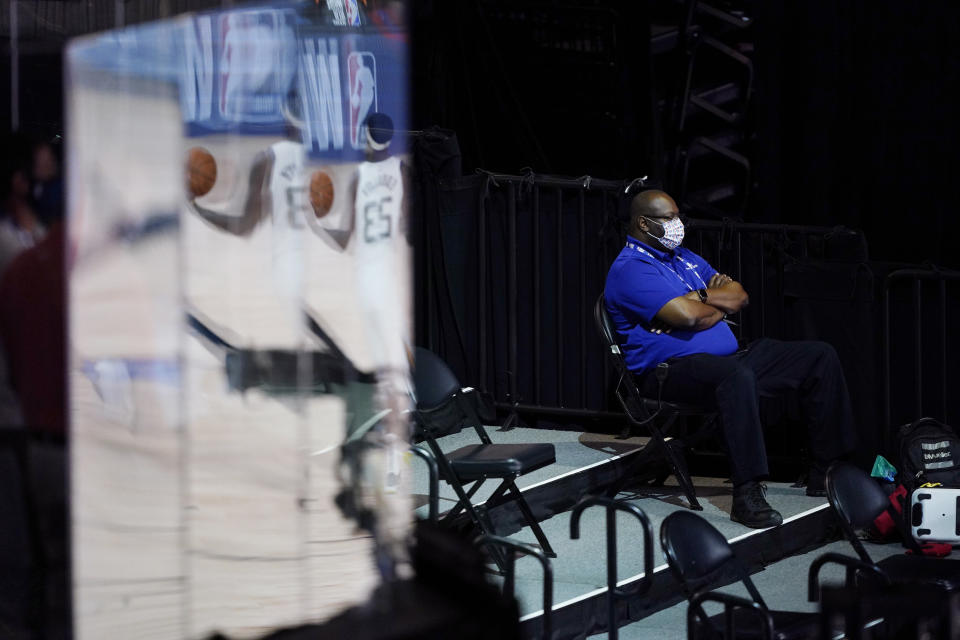 A man wearing a mask watches during halftime of an NBA basketball game between the Utah Jazz and the Oklahoma City Thunder, Saturday, Aug. 1, 2020, in Lake Buena Vista, Fla. (AP Photo/Ashley Landis, Pool)