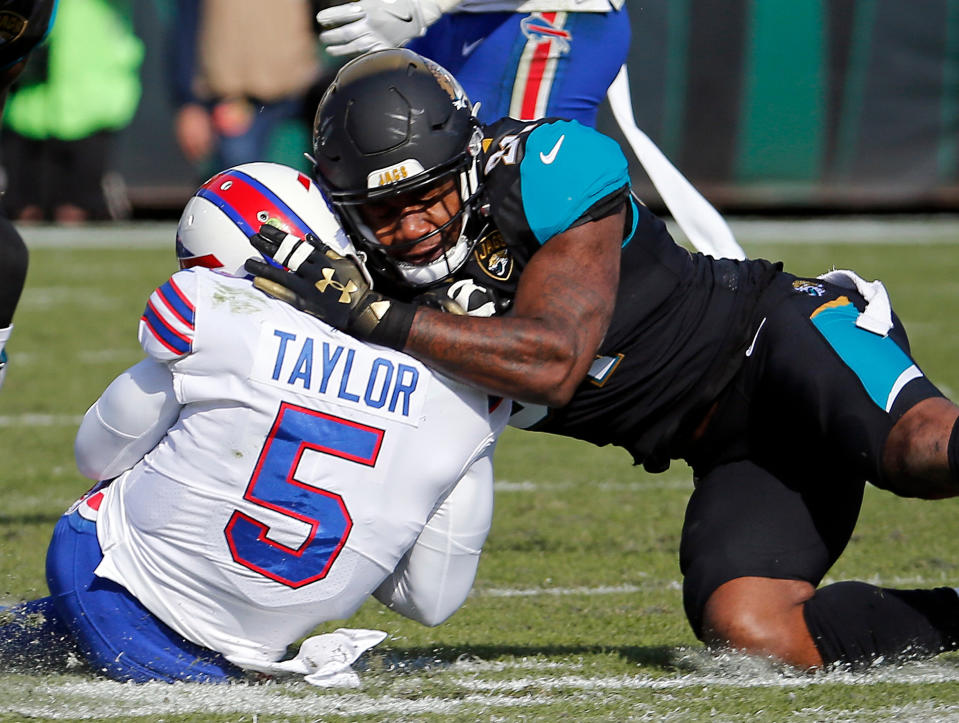 FILE - In this Jan. 7, 2018, file photo, Jacksonville Jaguars defensive end Yannick Ngakoue, right, draws a penalty by hitting Buffalo Bills quarterback Tyrod Taylor (5) with helmet-to-helmet contact in the first half of an NFL wild-card playoff football game, in Jacksonville, Fla. The Jaguars have suspended All-Pro cornerback Jalen Ramsey and defensive end Dante Fowler for violating team rules and conduct unbecoming a Jaguars football player. Fowler was involved in several fights, including one after practice with Ngakoue. (AP Photo/Stephen B. Morton, File)