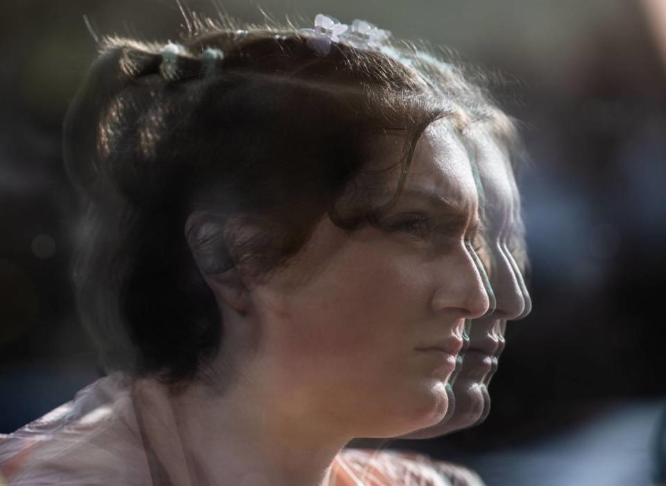 Lily Bourne is reflected on a cafe window in downtown Davis as they talk about living in a city where their mother Beth Bourne is the chapter president for Moms for Liberty.