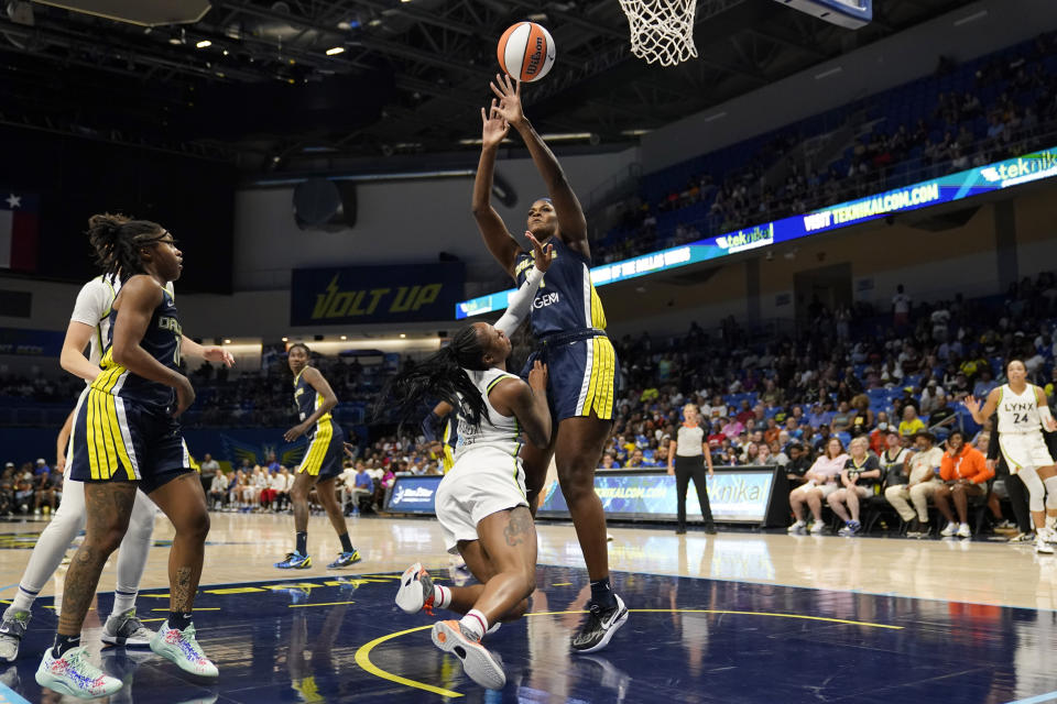 Minnesota Lynx guard Tiffany Mitchell, center left, loses control of the ball on a drive to the basket as Dallas Wings center Kalani Brown, center right, defends in the second half of a WNBA basketball game, Thursday, Aug. 24, 2023, in Arlington, Texas. (AP Photo/Tony Gutierrez)