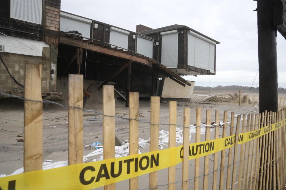 Caution tape is posted in front of a damaged structure on Dunes Club Beach, Thursday, Jan. 25, 2024, in Narragansett, R.I. Experts say erosion and receding shorelines are becoming more common due to ocean rise and climate change. (AP Photo/Steven Senne)