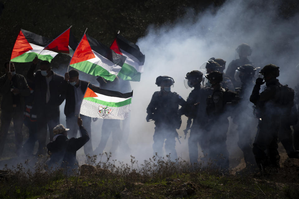 FILE - In this Dec. 3, 2020. file photo, Israeli border police officers and Palestinians clash during a protest against the expansion of Israeli Jewish settlements near the West Bank town of Salfit. One of the world's best-known human rights groups says Israel is guilty of the international crimes of apartheid and persecution. Human Rights Watch cites discriminatory policies toward Palestinians within Israel's own borders and in the occupied territories. In so doing, the New York-based group joins a growing number of commentators and rights groups that consider Israel and the territories as a single entity in which Palestinians are denied basic rights that are granted to Jews. (AP Photo/Majdi Mohammed, File)