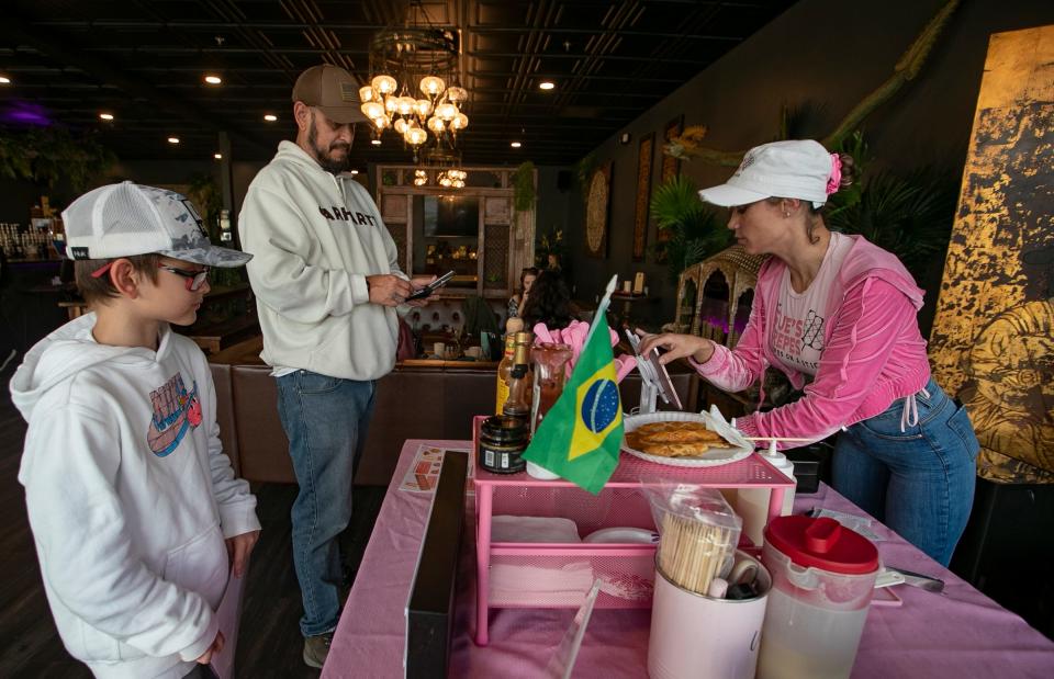 Lance Koprowski and his son Rome, place an order with Suelen Allen, owner of Sue's Crepes.