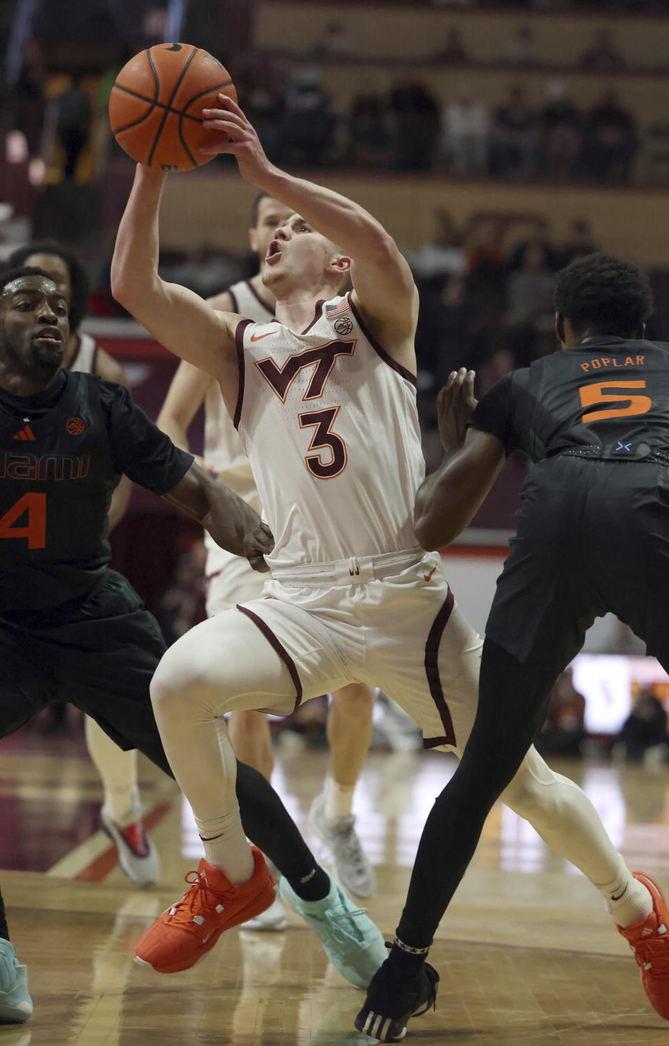 Virginia Tech's Sean Pedulla (3) drives and score past Miami defenders Bensley Joseph (4) and Wooga Poplar (5) in the first half of an NCAA college basketball game Saturday, Jan. 13, 2024, in Blacksburg, Va. (Matt Gentry/The Roanoke Times via AP)