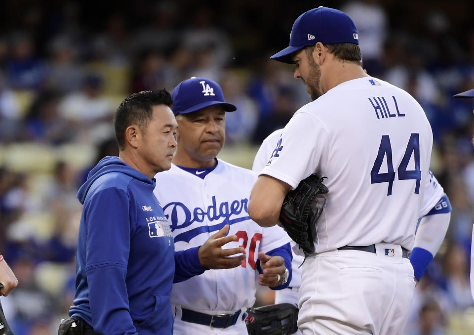 Los Angeles Dodgers starting pitcher Rich Hill, right, is taken out of the game by manager Dave Roberts, center, due to an injury prior to the second inning of the team's baseball game against the San Francisco Giants on Wednesday, June 19, 2019, in Los Angeles. (AP Photo/Mark J. Terrill)