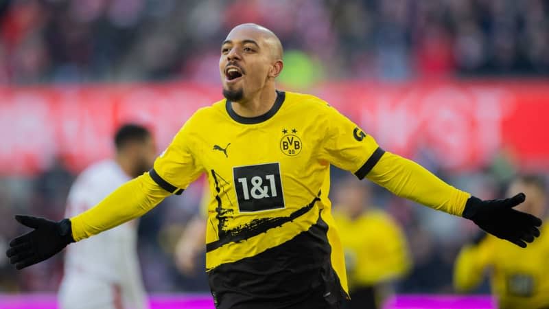 Dortmund's Donyell Malen celebrates scoring his side's first goal during the German Bundesliga soccer match between 1. FC Cologne and Borussia Dortmund at the RheinEnergieStadion. Rolf Vennenbernd/dpa