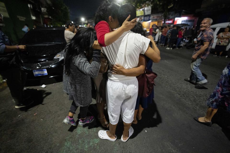 A man who was arrested under the ongoing "state of exception" is embraced by relatives after being released, outside a detention center in San Salvador, El Salvador, Saturday, Oct. 15, 2022. Under the measure authorities have made waves of arrests often with very little evidence. Generally, those arrested are accused of belonging or associating with one of the country’s powerful street gangs. (AP Photo/Moises Castillo)